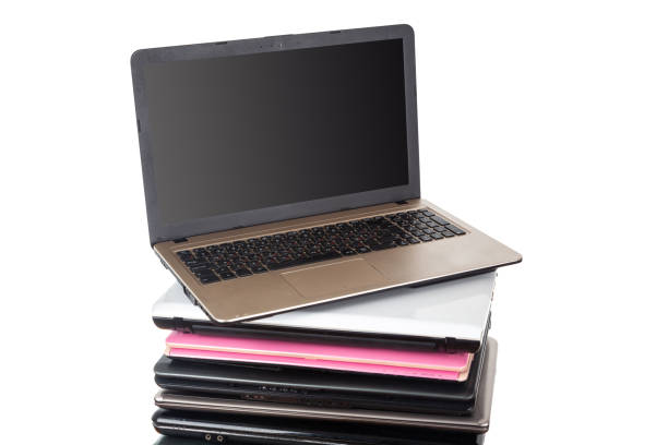 Stack of used laptops in different colors and models. Tha notebooks for repair and service.