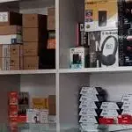 Shelves filled with computer accessories, hardware products, and electronic items in a tech store